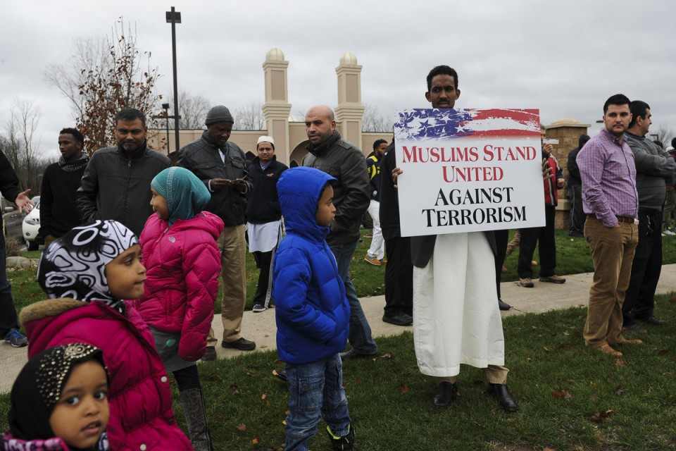 "Muslims stand against terrorism with red, white and blue signs"